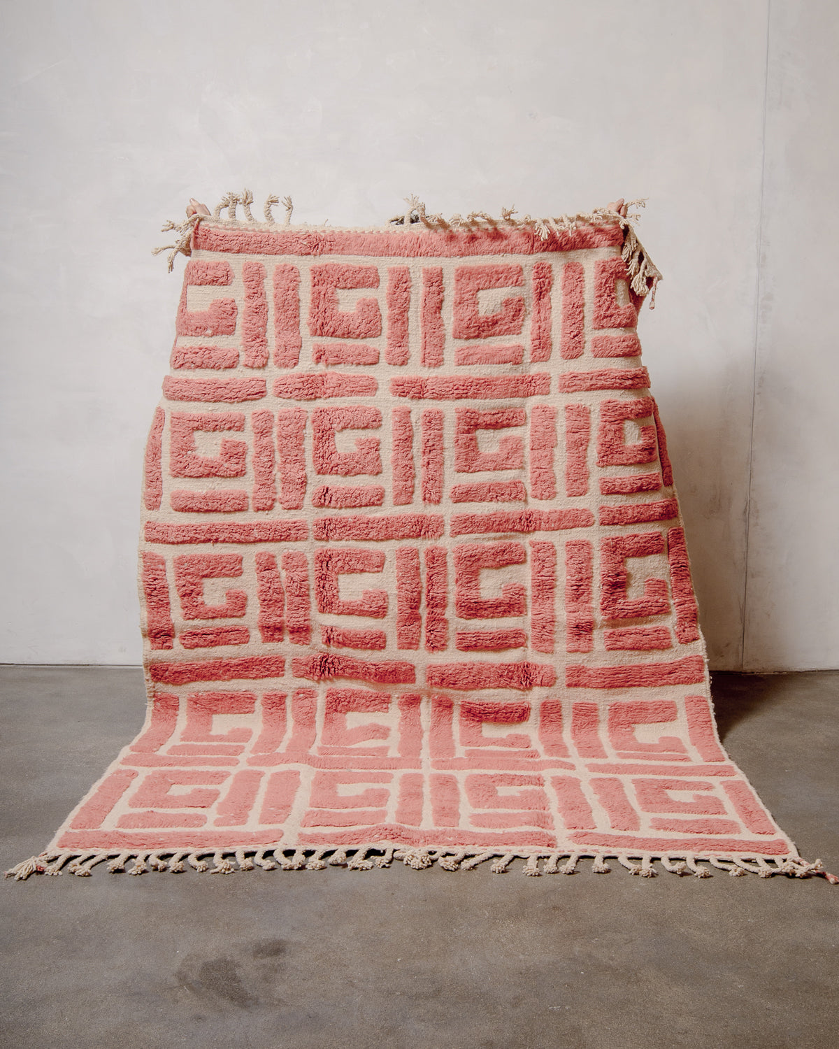 Berberlin Beniourain rug with textural design made up of thick knotted wool pile in a soft dusty rose colour and flat woven base in natural cream.